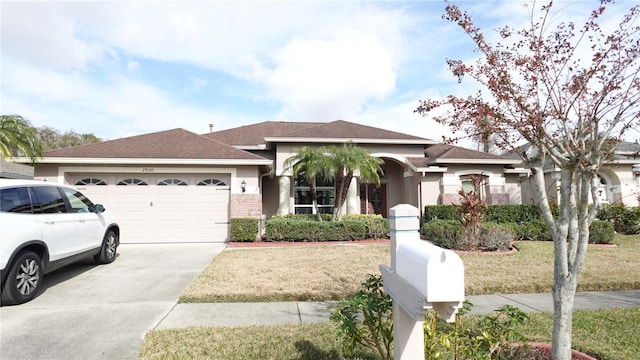 view of front of home with a garage and a front lawn