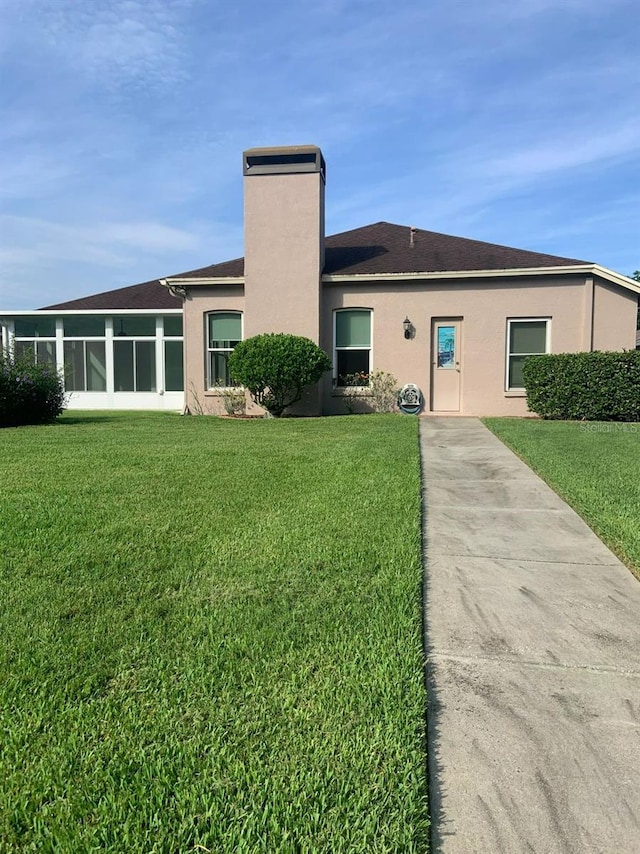 rear view of house featuring a lawn