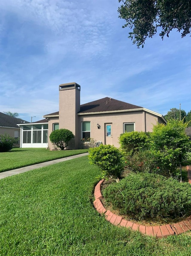 back of house with a sunroom and a yard