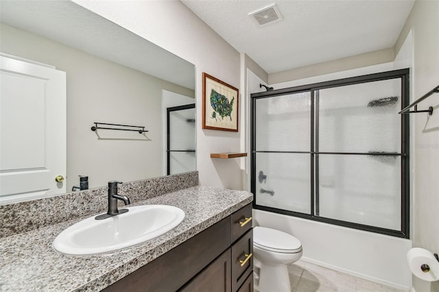 full bathroom with toilet, bath / shower combo with glass door, a textured ceiling, vanity, and tile patterned flooring