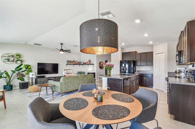 dining space featuring light tile patterned flooring, sink, vaulted ceiling, a textured ceiling, and ceiling fan