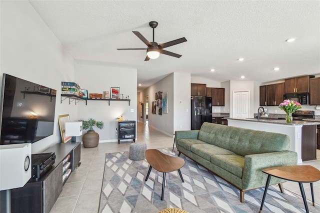 living room featuring light tile patterned flooring, sink, vaulted ceiling, and a textured ceiling