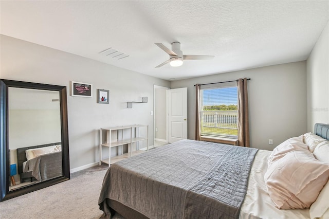 bedroom with ceiling fan, carpet, and a textured ceiling