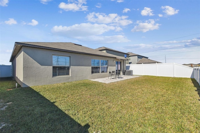 back of property with central AC, a patio, and a lawn