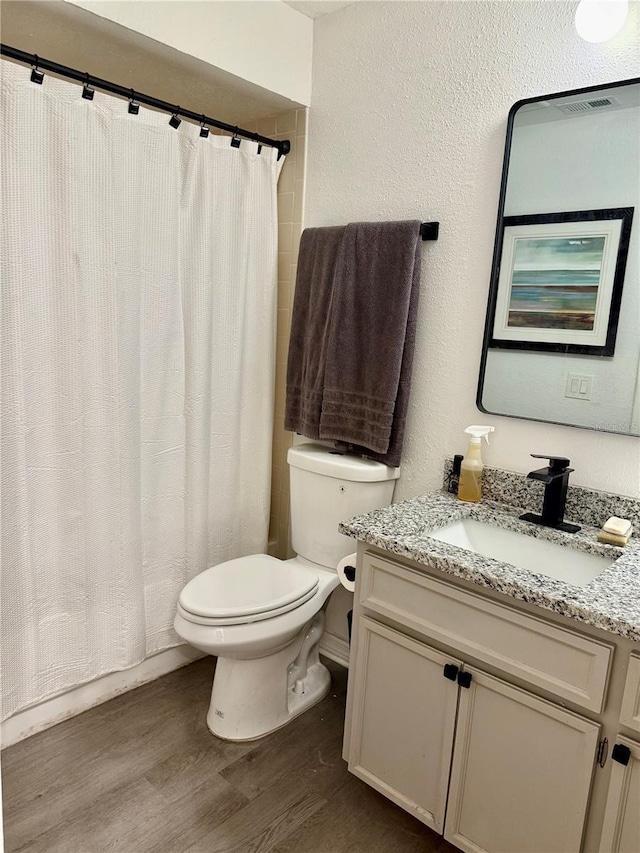 bathroom featuring vanity, wood-type flooring, and toilet