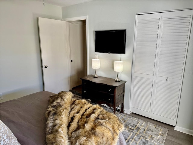 bedroom with dark wood-type flooring and a closet