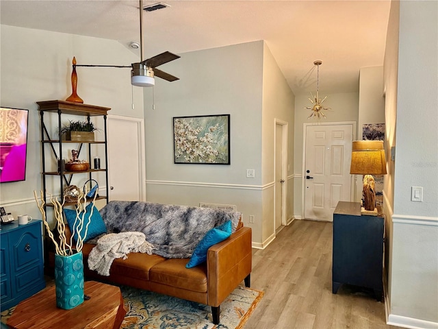 living room with ceiling fan, lofted ceiling, and light hardwood / wood-style floors