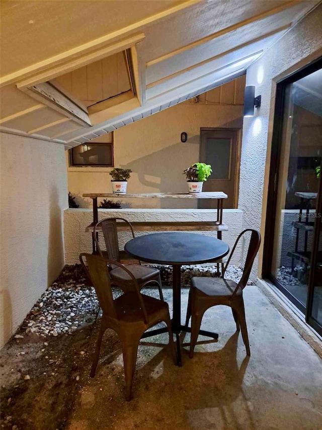 dining space with lofted ceiling and concrete floors