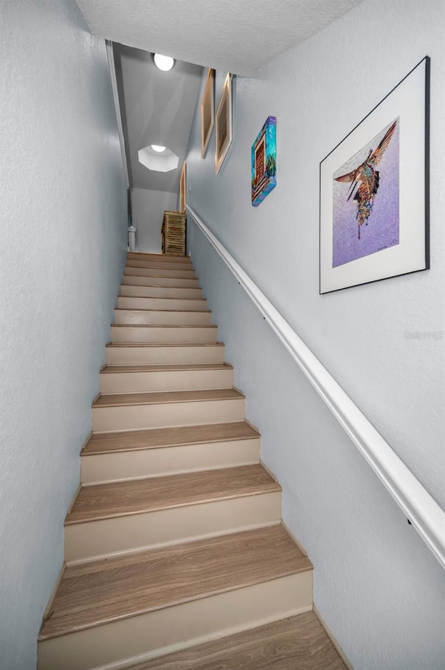 stairs featuring hardwood / wood-style floors