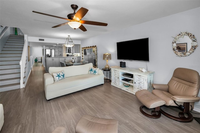 living room with ceiling fan and dark hardwood / wood-style flooring