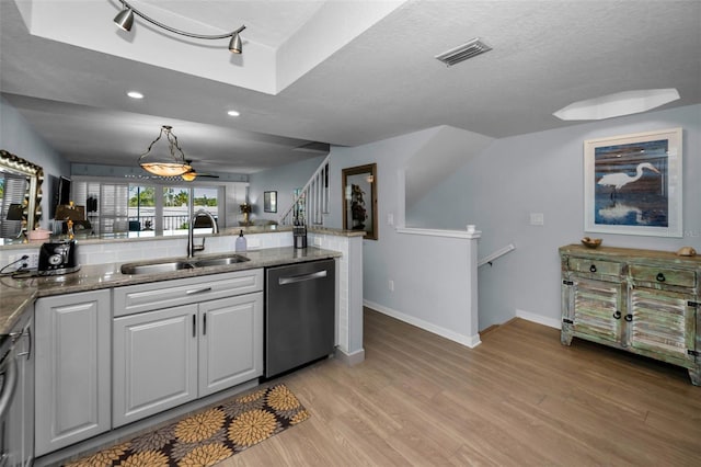 kitchen with pendant lighting, sink, light hardwood / wood-style flooring, white cabinetry, and stainless steel dishwasher