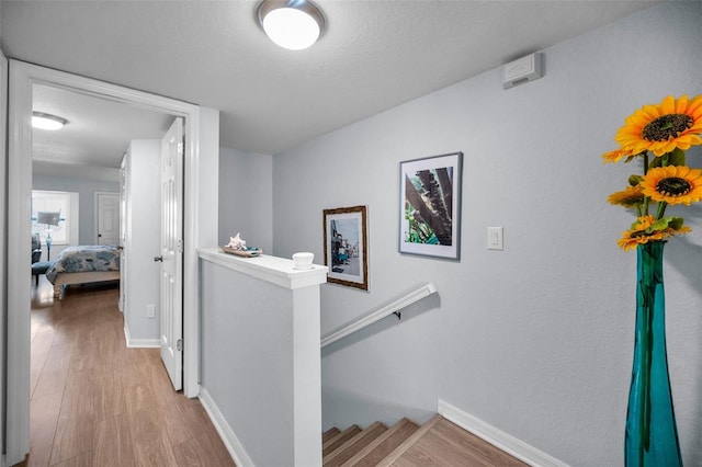 corridor featuring a textured ceiling and light wood-type flooring