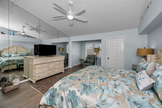 bedroom featuring dark hardwood / wood-style flooring, vaulted ceiling, and ceiling fan