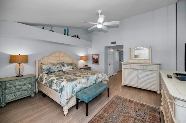 bedroom with hardwood / wood-style flooring, vaulted ceiling, and ceiling fan