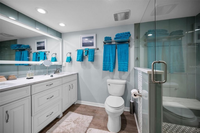 bathroom featuring wood-type flooring, toilet, an enclosed shower, and vanity