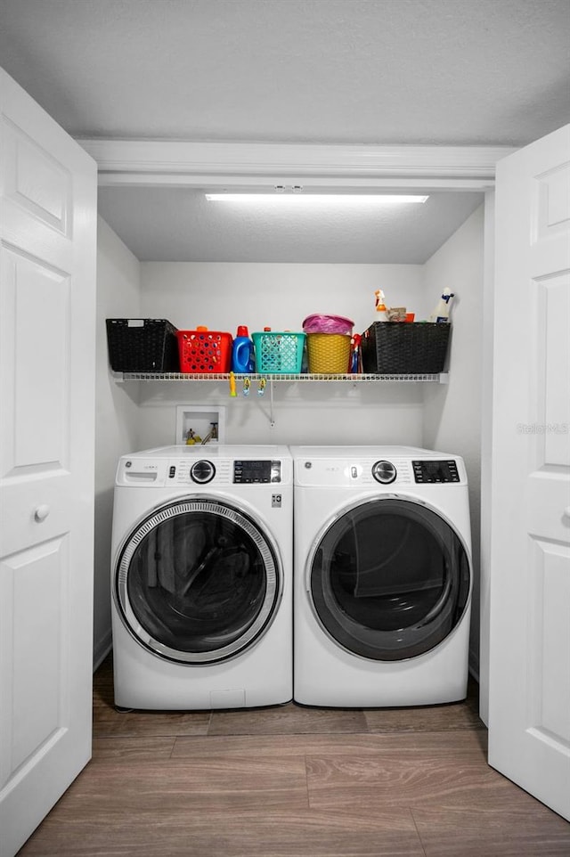 laundry area with wood-type flooring and separate washer and dryer