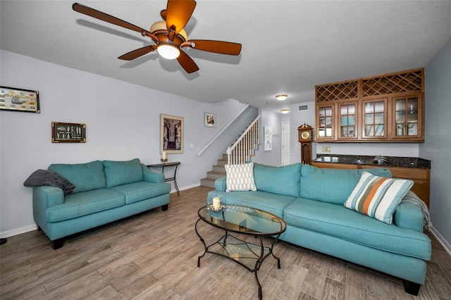 living room featuring hardwood / wood-style floors and ceiling fan