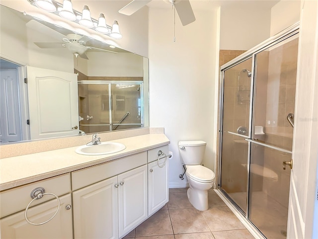 bathroom featuring ceiling fan, tile patterned flooring, vanity, toilet, and walk in shower