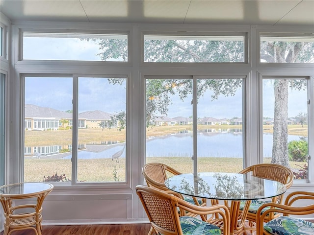 sunroom featuring a wealth of natural light and a water view