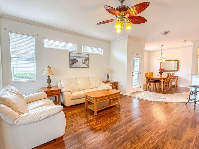 living room with hardwood / wood-style flooring, ceiling fan, and ornamental molding