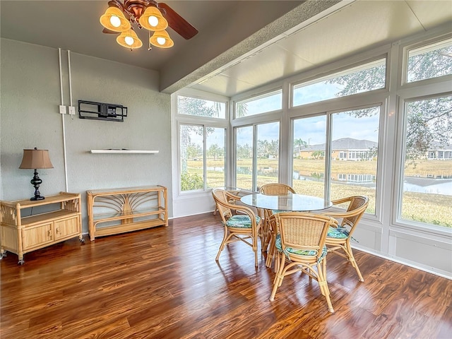 sunroom / solarium featuring beamed ceiling and ceiling fan