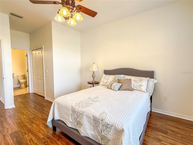 bedroom with ensuite bath, dark wood-type flooring, a closet, and ceiling fan