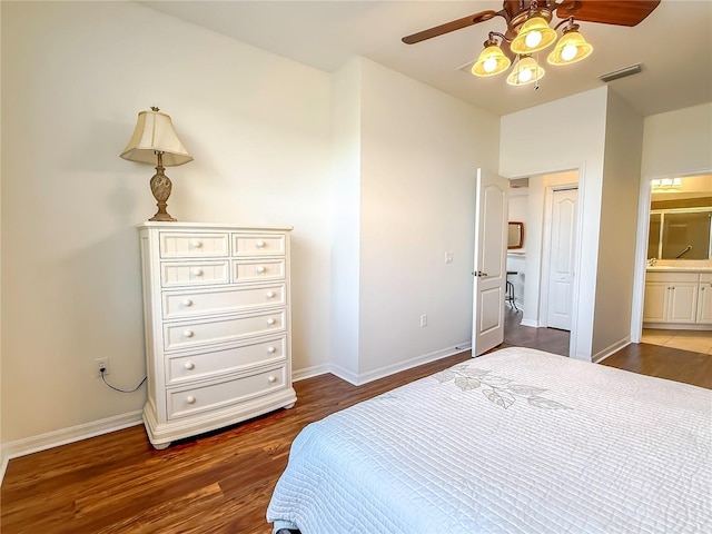 bedroom with connected bathroom, dark wood-type flooring, sink, and ceiling fan