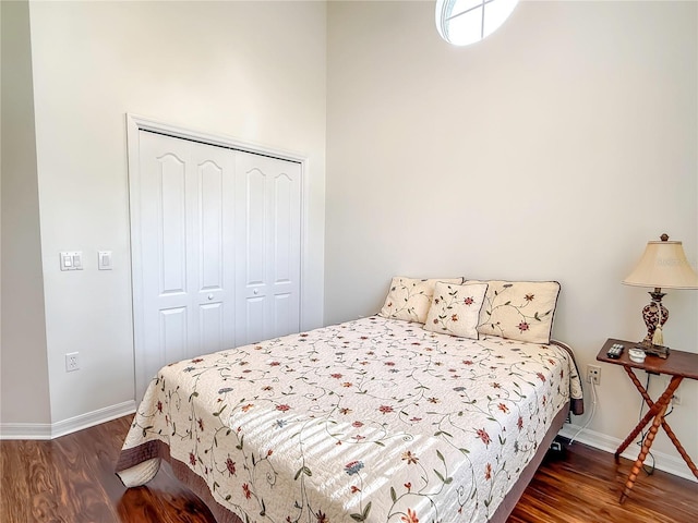 bedroom with dark hardwood / wood-style flooring and a closet