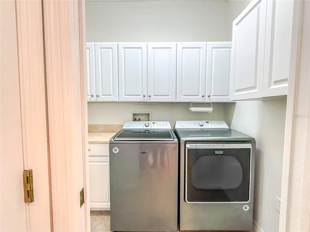 washroom with cabinets and washer and clothes dryer