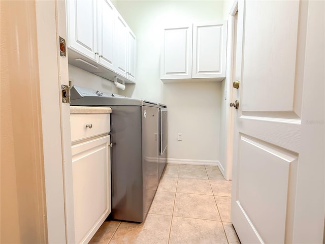 laundry room with cabinets, washing machine and clothes dryer, and light tile patterned flooring