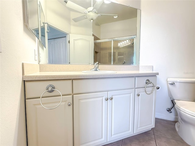 bathroom with ceiling fan, an enclosed shower, vanity, tile patterned floors, and toilet