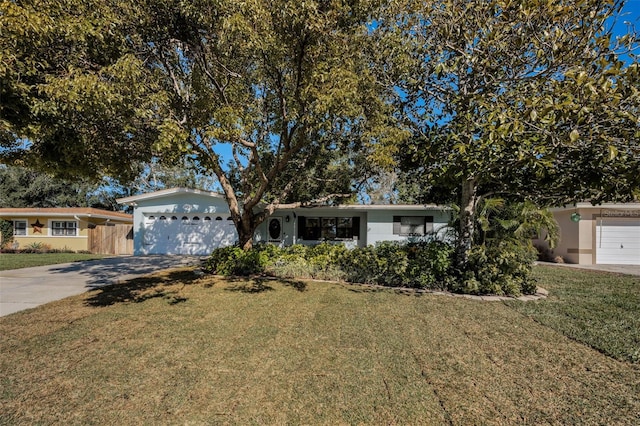 ranch-style house featuring a garage and a front lawn