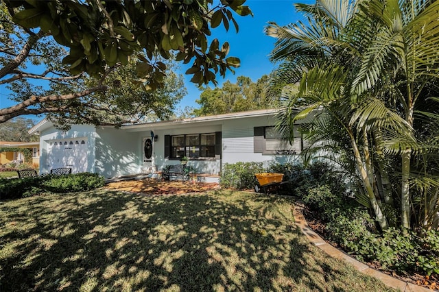 back of property featuring a garage and a yard