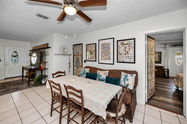 dining space featuring ceiling fan, a textured ceiling, and light tile patterned floors