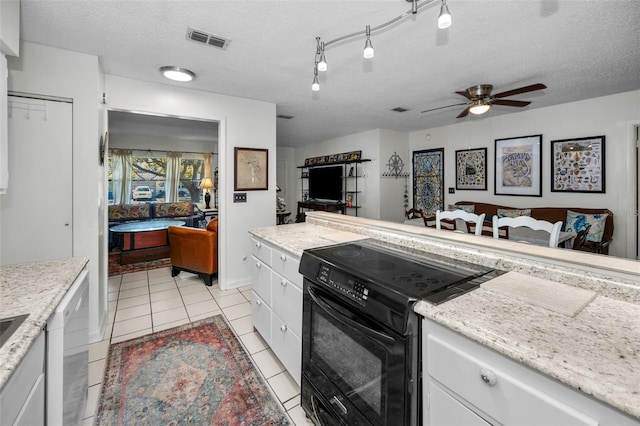 kitchen with white cabinetry, black range with electric stovetop, light tile patterned floors, and a textured ceiling