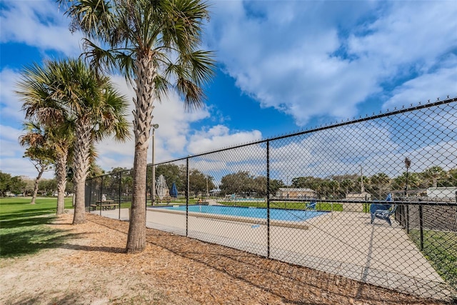 exterior space featuring a tennis court and fence