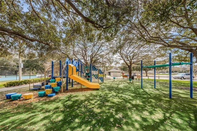 communal playground featuring fence and a yard