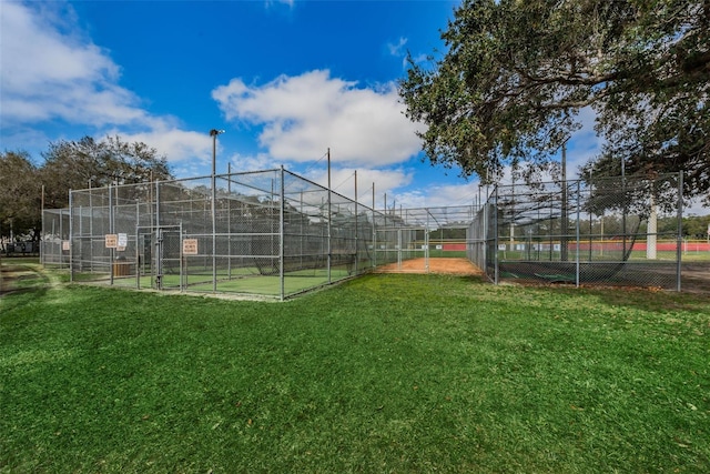 view of community with a tennis court, a yard, and fence