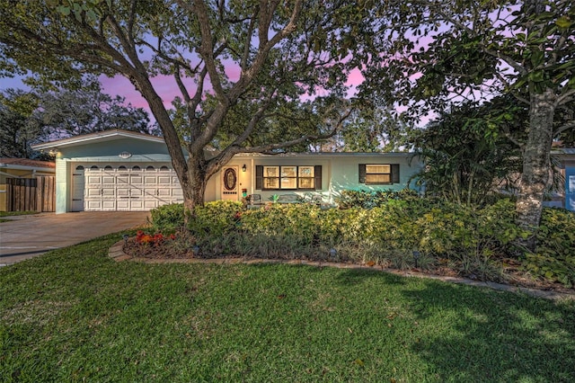 single story home featuring an attached garage, concrete driveway, a front yard, and fence