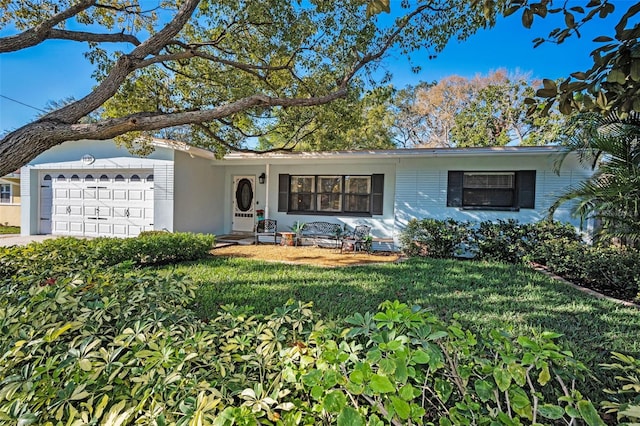 ranch-style house with an attached garage, driveway, a front yard, and stucco siding