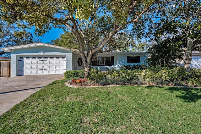 ranch-style home featuring a garage, concrete driveway, and a front lawn