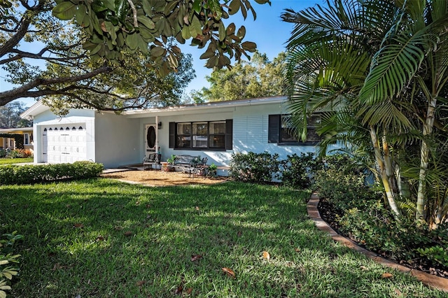 single story home with a front lawn, an attached garage, and stucco siding