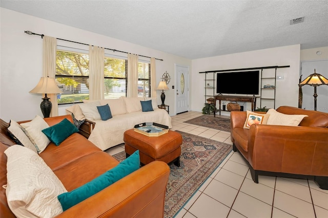 living area with visible vents, a textured ceiling, and light tile patterned flooring