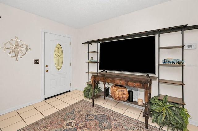 foyer entrance with a textured ceiling, baseboards, and light tile patterned floors