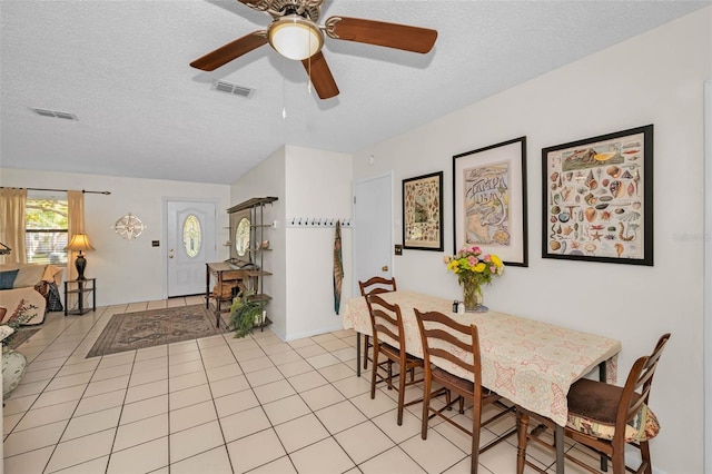 dining room featuring light tile patterned floors, visible vents, and a textured ceiling