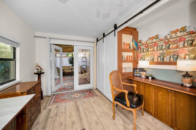 office area featuring plenty of natural light, a barn door, and light wood-style flooring