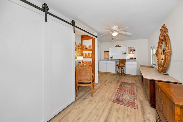 interior space with light wood finished floors and a barn door