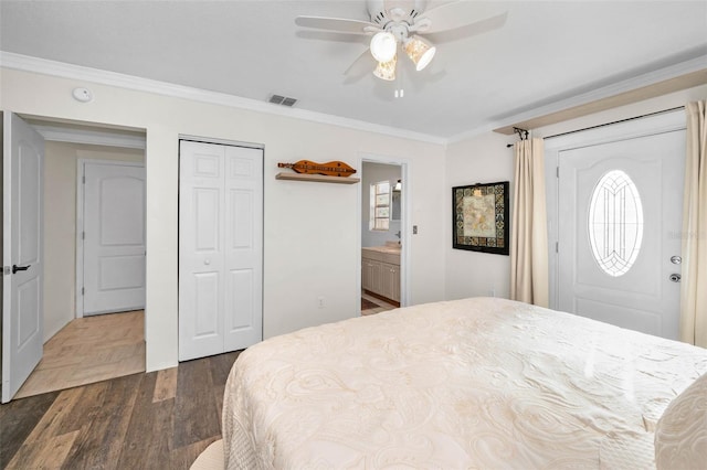 bedroom featuring visible vents, a ceiling fan, dark wood-style floors, ornamental molding, and a closet