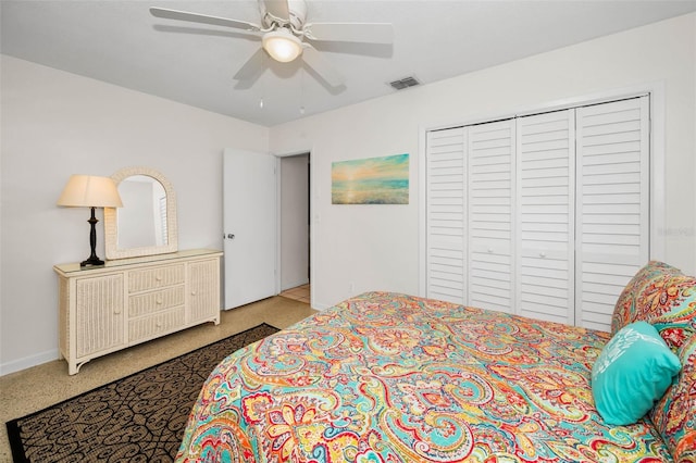 bedroom with ceiling fan, speckled floor, visible vents, baseboards, and a closet