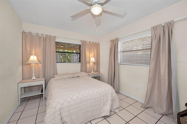 bedroom featuring ceiling fan, light tile patterned floors, and baseboards